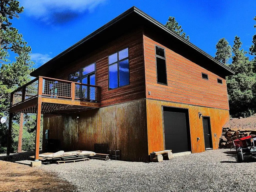 Aspen home with wood siding, a deck, and a garage